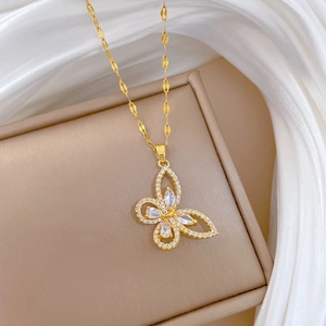 Macro detail of a gold butterfly pendant necklace with sparkling cubic zirconia inlay