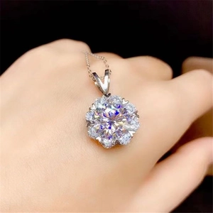 Detail of flower-shaped pendant with a 2ct sparkling round-cut stone on a model hand
