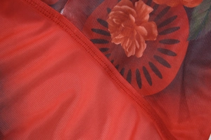 Dettaglio ravvicinato del tessuto mesh con stampa di rose rosse e cuciture rifinite