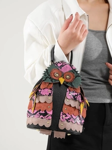 Ethnic owl-shaped handbag featuring colorful patchwork and decorative metal rivets