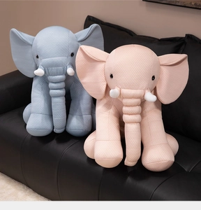 Detailed waffle texture of cute pink and blue elephant plush toys on a leather sofa