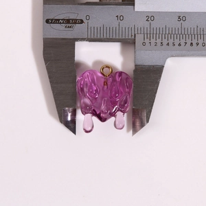 Macro shot showing purple resin heart pendant dimensions measured with a golden caliper