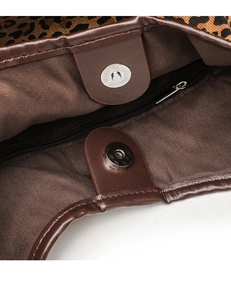 Close-up of leopard print tote bag interior featuring magnetic snap and zip pocket