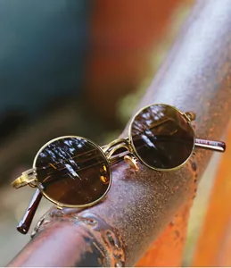 Steampunk round sunglasses on industrial metal pipe showing copper frame and retro style