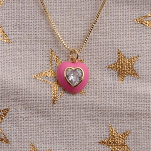 Detailed shot of pink enamel heart pendant with cubic zirconia on gold box chain
