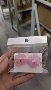 Detailed macro view of pink floral petal stud earrings with a matte frosted texture finish