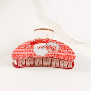 Detail of red Christmas hair claw clip with Santa Claus pattern and snowflake prints