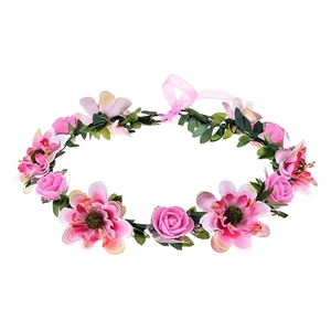 Pink artificial flower crown with large roses and green leaves on a white background