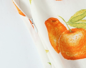 Nahaufnahme des verdeckten Reißverschlusses und Orangenmusters auf dem Leinenkleid