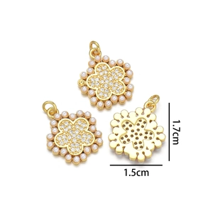 Detail view of gold flower pendants with micro-inlaid pearls and 1.7cm size scale
