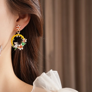Gros plan de boucles d'oreilles vintage lapin et fleurs portées par un mannequin