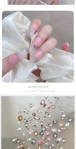 Detail of mixed color mini zircons and butterfly chains on manicured nails