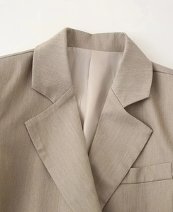 Detail view of the lapel and collar on a khaki slim fit buttoned blazer jacket