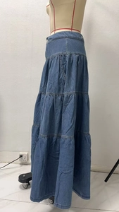 Dettaglio di una gonna lunga in denim a più strati con design bohémien a balze
