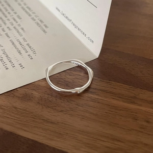 Detailaufnahme eines unregelmäßigen S925 Sterlingsilberrings auf rustikalem Holzhintergrund