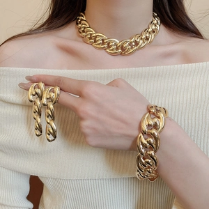Close-up of a gold metal chunky chain jewelry set including necklace, bracelet, and earrings