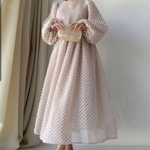 Elegant apricot popcorn fabric puff sleeve dress with a flared hem and round neck