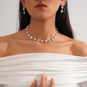 Elegant silver jewelry set with rhinestone flower necklace and matching earrings on model