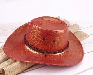 Detail of red cowboy hat featuring gold leaf patterns and brown braided rope trim