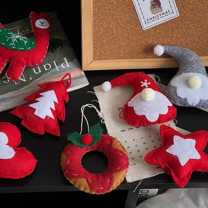 Close-up of handmade felt Christmas ornaments featuring Santa, reindeer and tree shapes