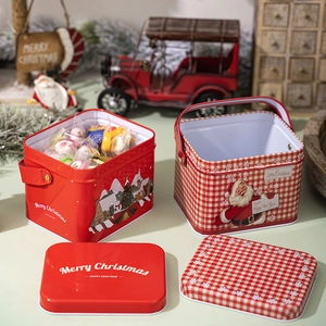 Macro shot of red Christmas tin box with handle and Merry Christmas print in festive scene