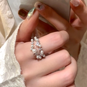 Dettaglio anello a strati in argento con perle eleganti e zirconi luccicanti