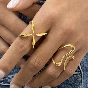 Set of two gold stainless steel rings featuring a starburst design and wavy lines