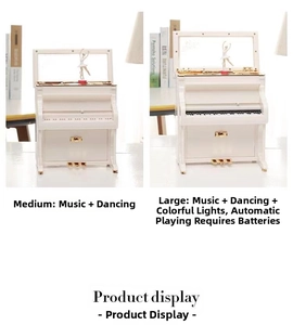 Close-up of white grand piano music boxes with rotating ballet dancers and gold accents