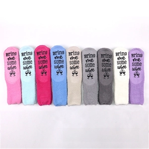Detail of coral fleece sleeping socks with non-slip wine quote lettering on the sole