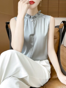 Detail of silver silk satin camisole featuring ruffle stand collar and pearl button