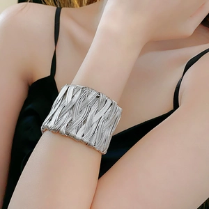 Close-up of a wide vintage silver twisted woven cuff bracelet on a female wrist