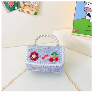 Détail du sac enfant en tweed bleu avec poignée en perles et breloque cerise