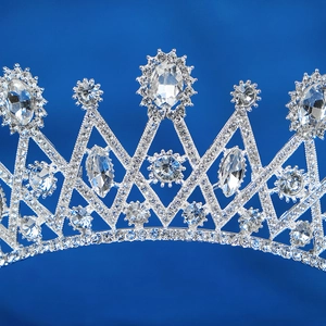 Close-up of silver bridal crown featuring brilliant rhinestones on a deep blue background