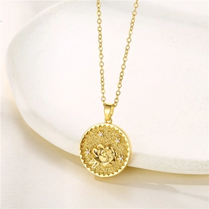 Detailed macro of gold stainless steel rose coin pendant with zircon crystal accents