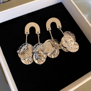 Detail of gold U-shaped earrings with hammered metal sequins on black velvet display