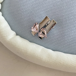 Close-up of two silver metal hair clips with pink heart-shaped crystal rhinestones