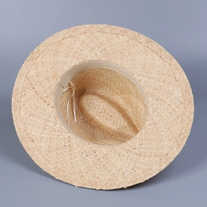 Close-up of Raffia sun hat interior showing adjustable drawstring and sweatband details