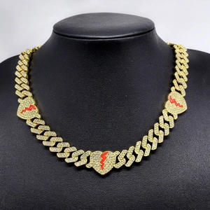 Men's 12mm gold Cuban link chain with iced out broken heart pendants on a display model