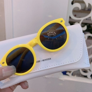Detail of yellow round frame children's sunglasses with dark lenses and protective storage case