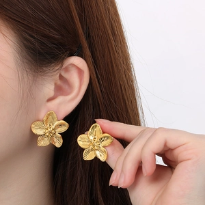 Close-up of 18K gold-plated stainless steel flower earrings with petal texture on ear