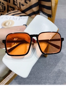 Detail view of square black half-frame sunglasses with translucent orange lenses