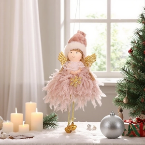 Cute pink plush angel ornament with gold wings and bell hanging by a Christmas tree