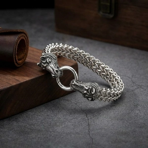 Close-up of vintage steel men's bracelet with dual horse head carving and woven chain