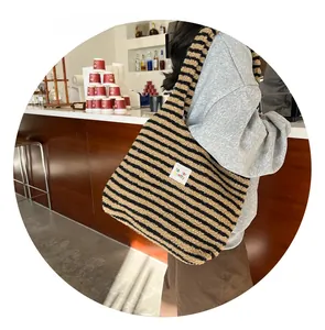 Detail of plush yellow and black striped tote bag with fair far pretty woven label