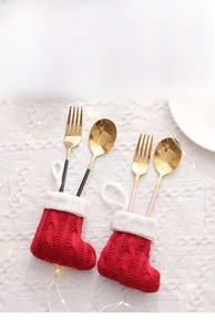 Close-up of red and white knit Christmas stocking cutlery holders on a festive table