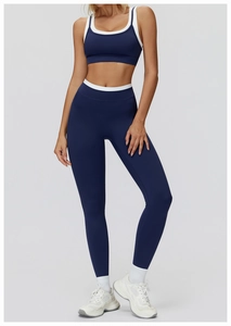 Detail of navy blue high-waist yoga set showing white contrast trim on sports bra and leggings