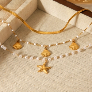 Set di tre bracciali dorati a tema marino con ciondoli a conchiglia e stella marina