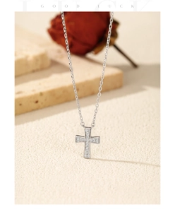 Macro shot of silver cross pendant necklace with sparkling pavé moissanite stones
