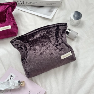 Detailed macro view of purple embossed velvet texture and white fabric label on travel pouch