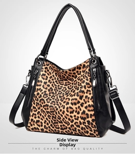 Detail view of large leopard print tote with black pebbled leather and vertical zippers